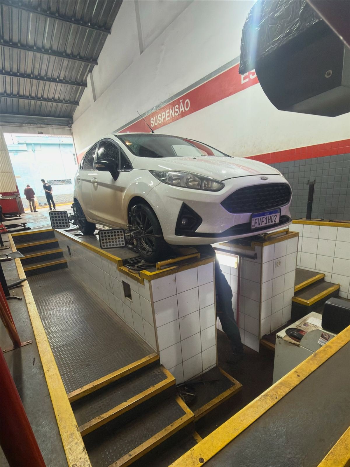 Revisão veicular com veículo elevado na Carlos Pneus